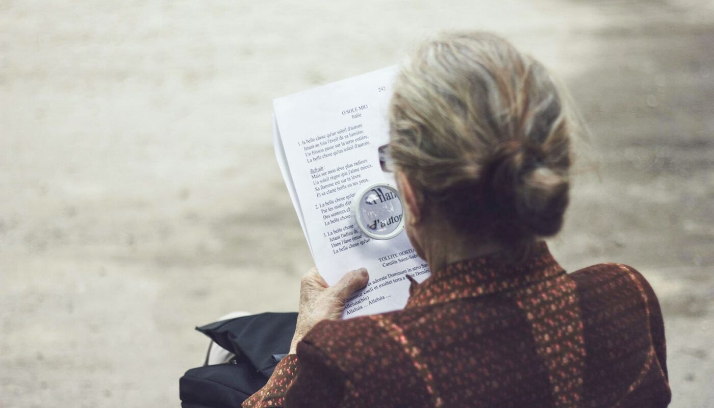 woman in brown top reading paper