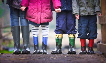 four children standing on dirt during daytime